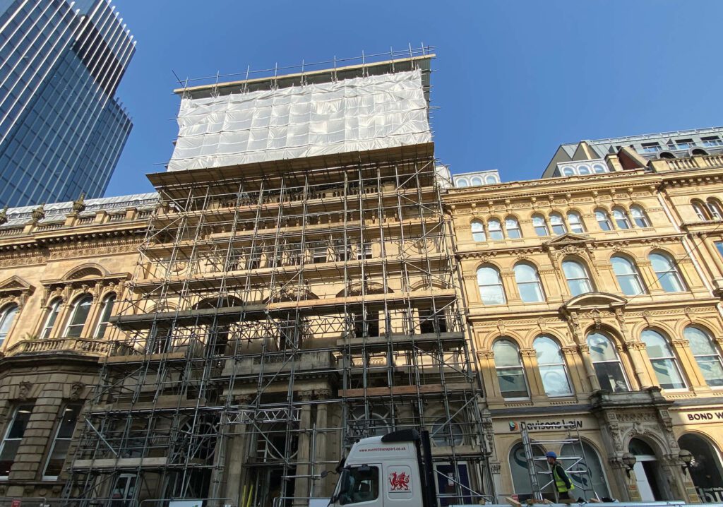 Scaffolding and protective sheeting to imposing building at 81 Colmore Row in Birmingham, as part of temporary works design, before commencement of structural alterations.