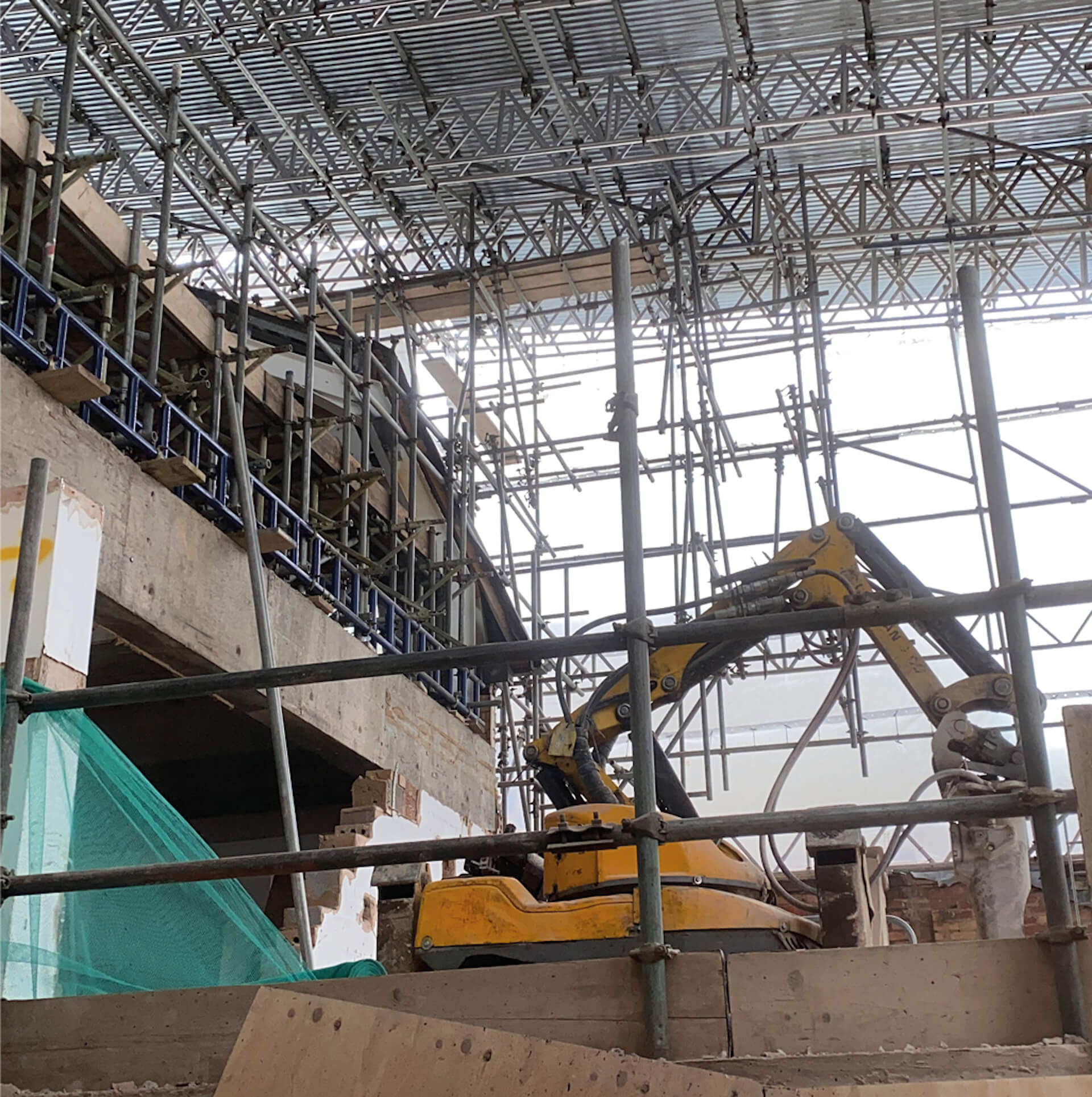 image of a remote controlled Brokk machine working onsite. Temporary scaffolding is all around it.