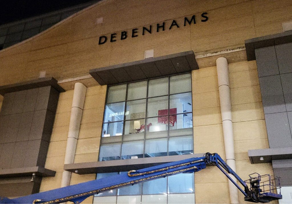 front of Debenhams shopping centre building with a crane lift in front of it.