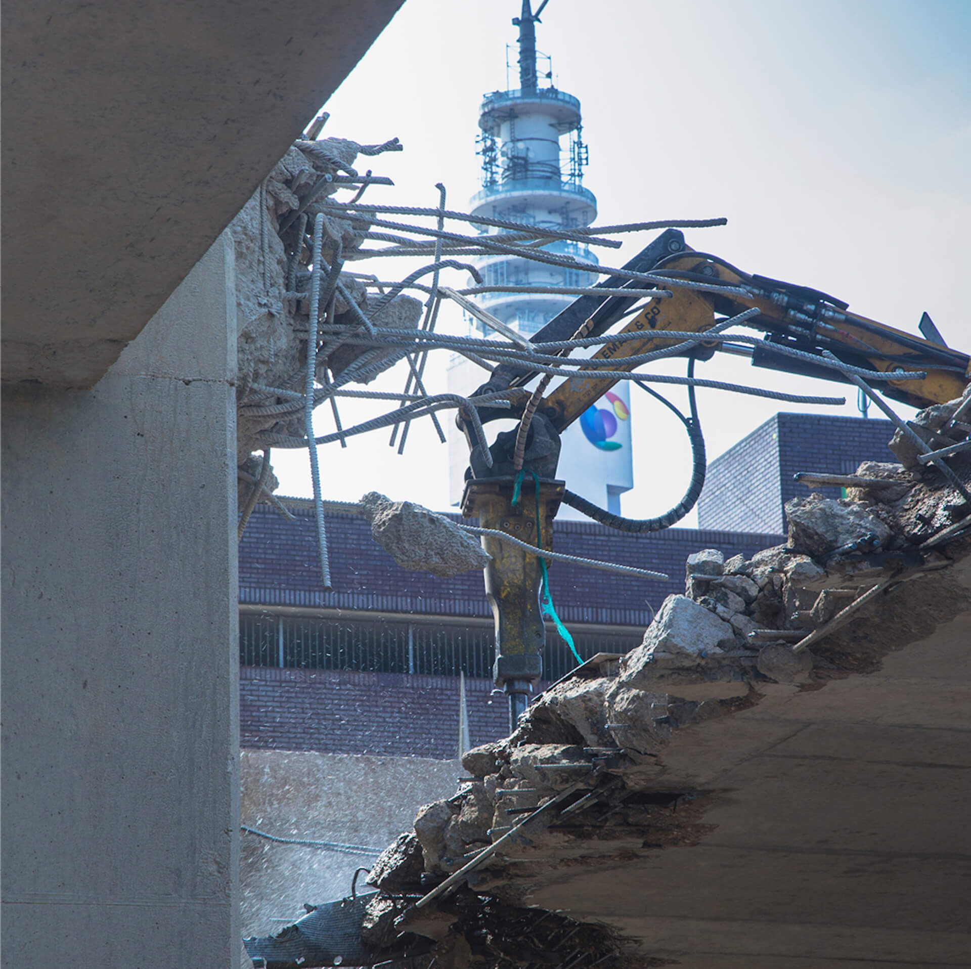 image of robotic demolition on a demolition site. Image shows the head of a Brokk machine drilling into concrete roof