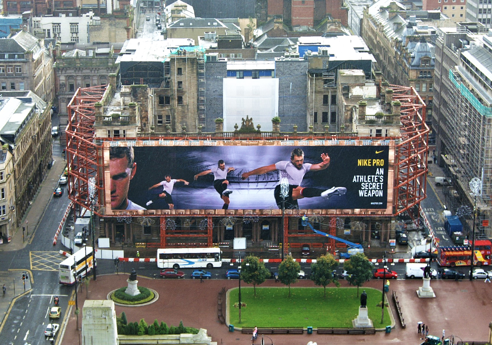 Aerial view of g1 building glasgow with temporary works steel propping positioned around the perimeter of the building. Large general advertising banner positioned to front of the building showing a Nike advert.