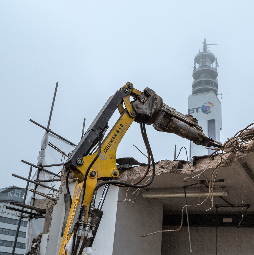 machine demolishing steels from top of partially deconstructed building. BT tower in background.